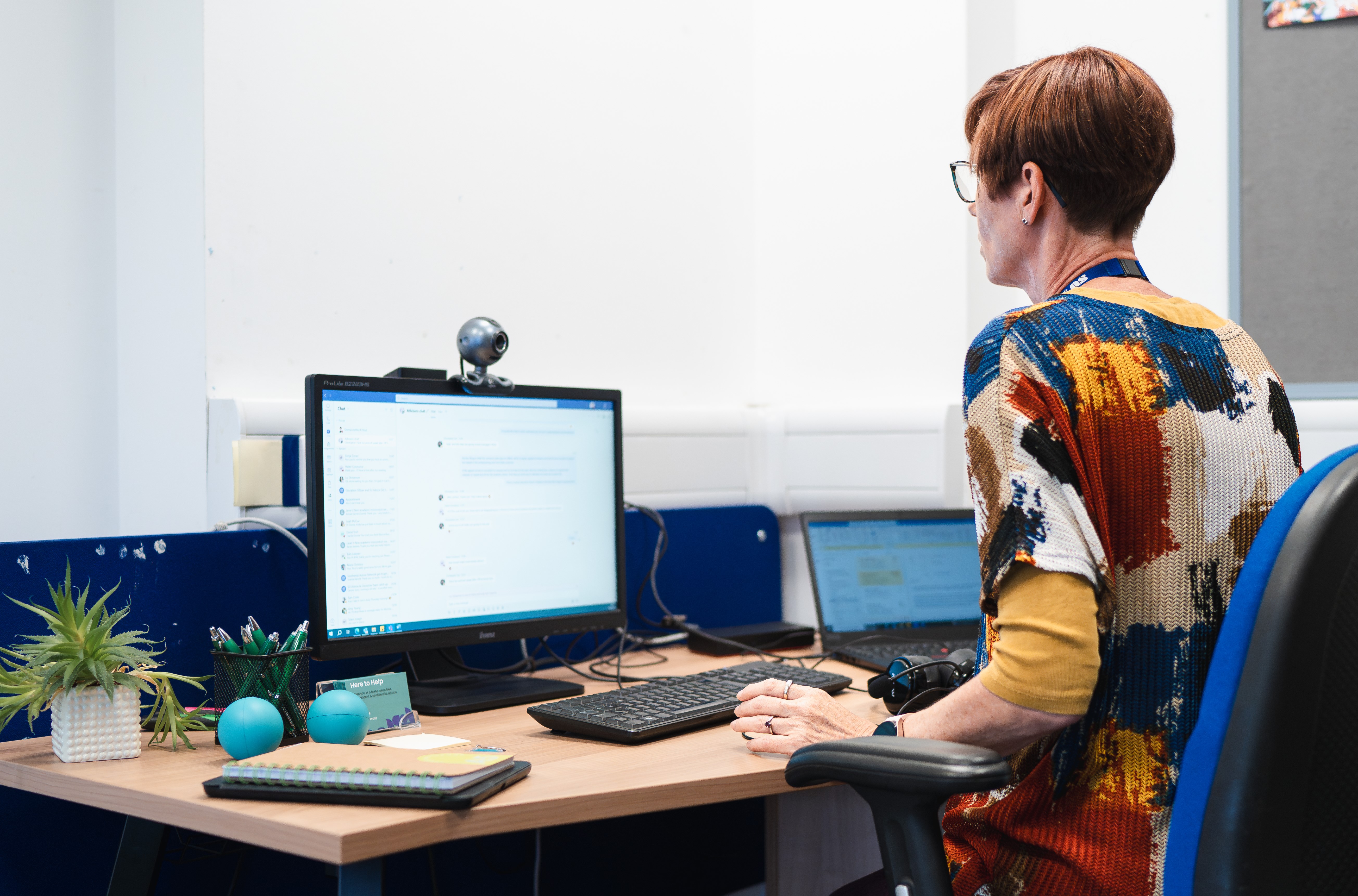 Advisor sits at desk looking at computer screen