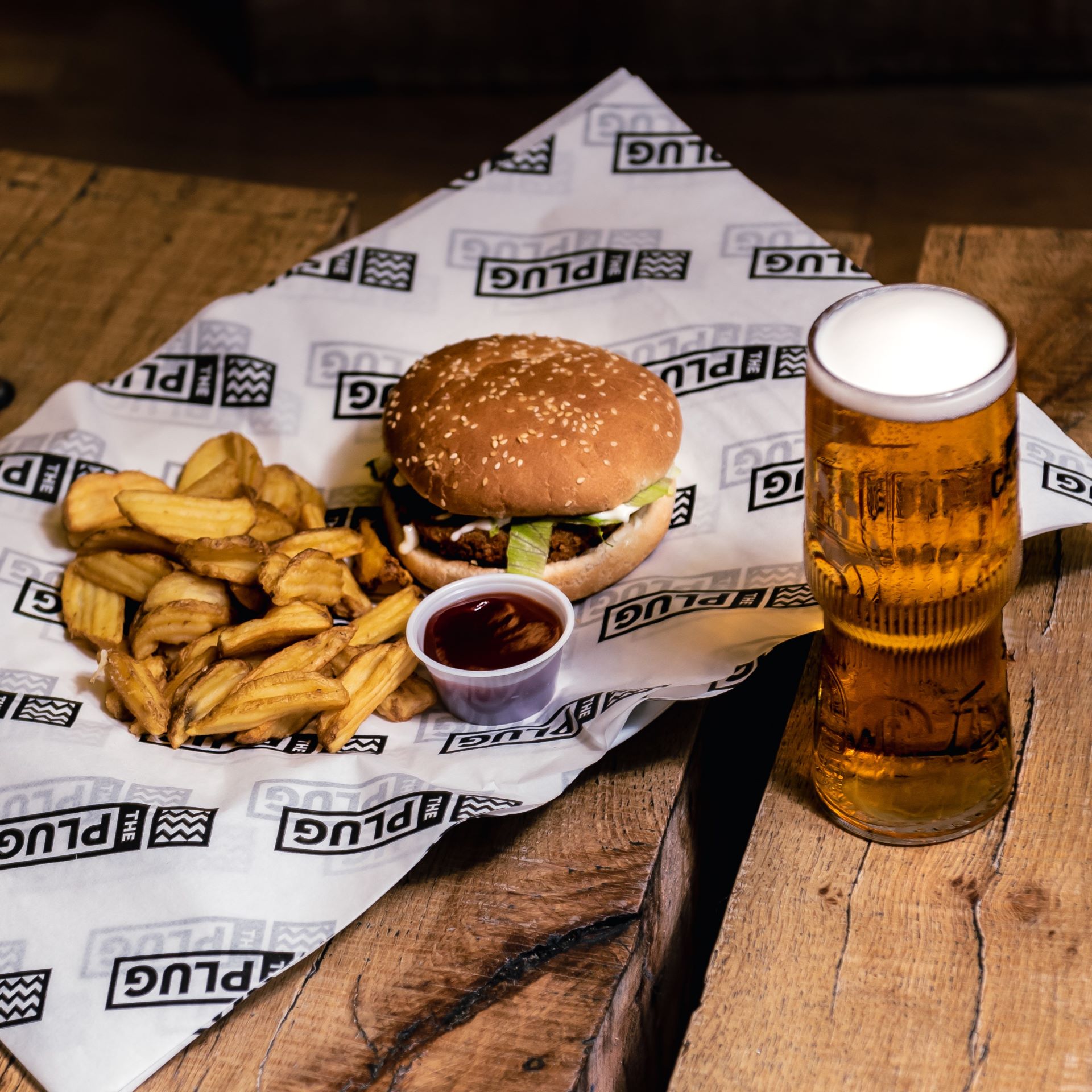 Burger, chips and pint laid out on table