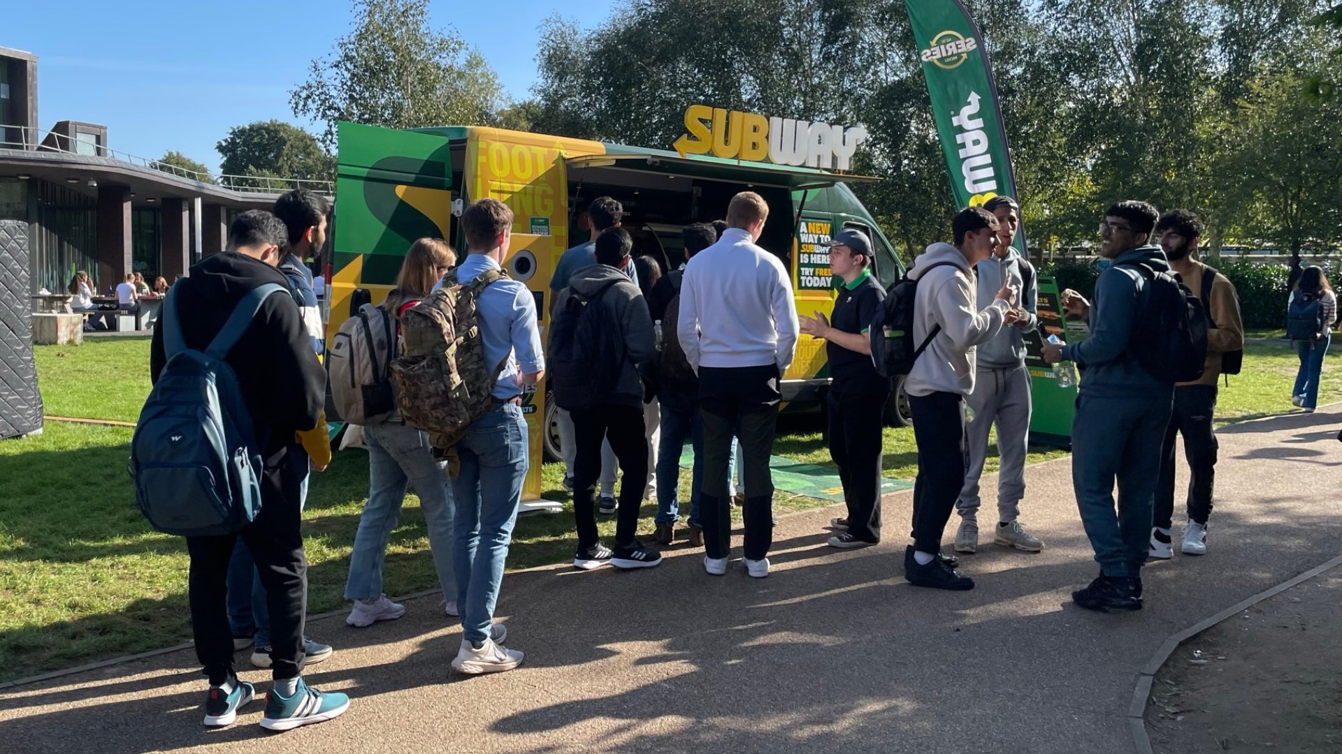 students lining up outside a subway van on campus